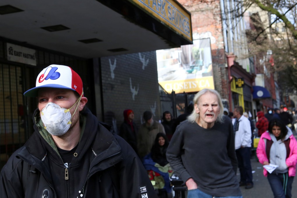 Adam Powell waits with other residents of the Downtown Eastside to collect his social assistance cheque in Vancouver, British Columbia, on Wednesday. Photo: Reuters
