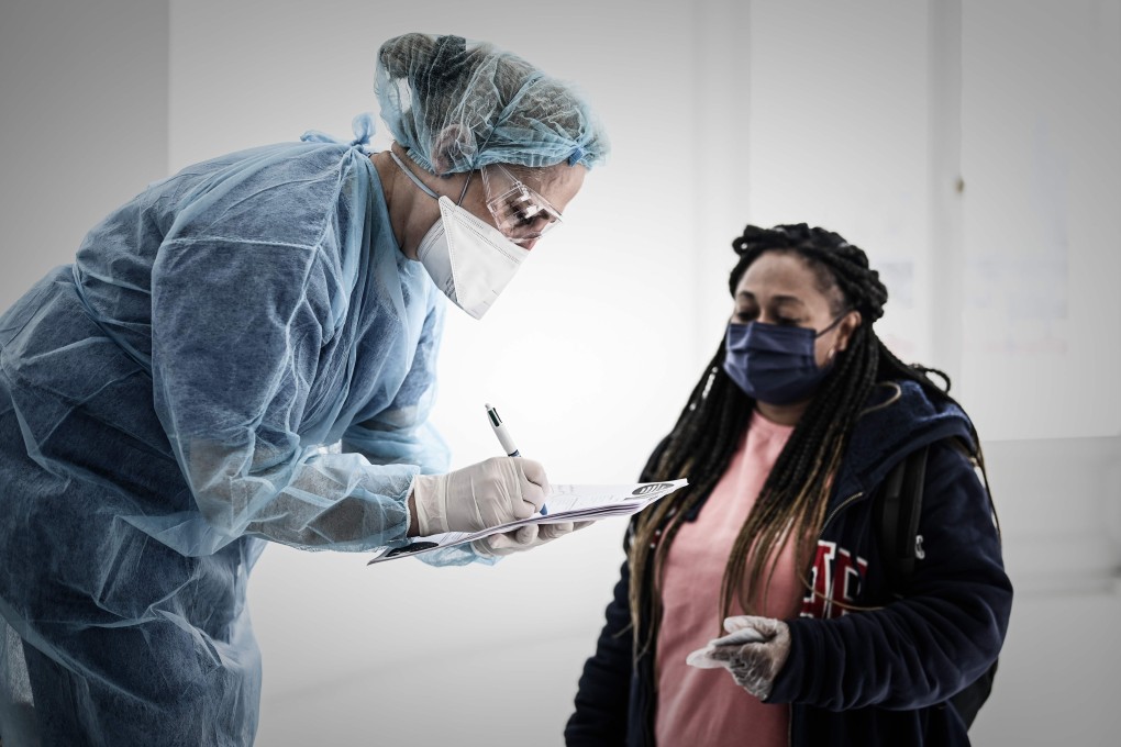A medical worker helps a woman wearing a protective mask at a testing centre in Paris on Friday. Photo: AFP