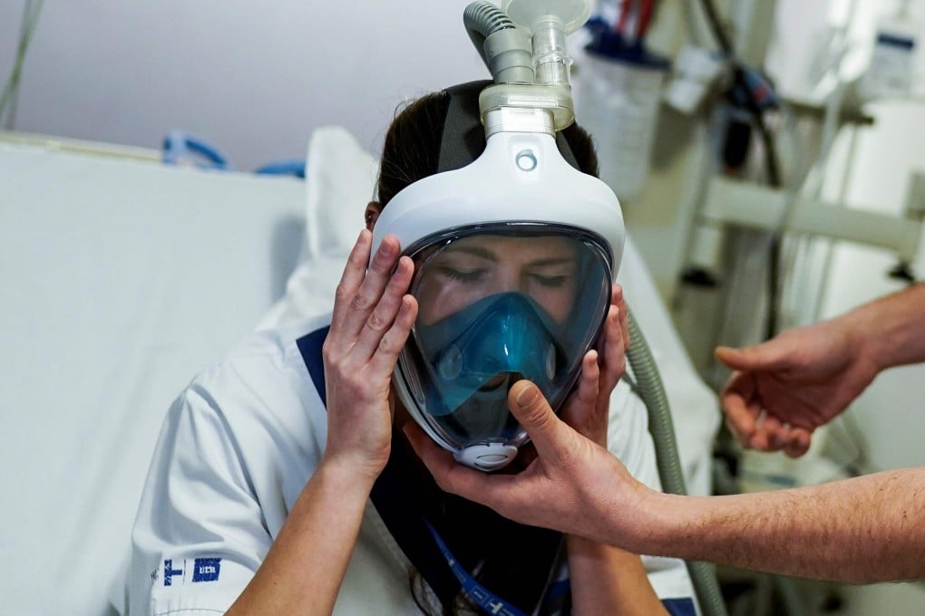 A medical worker tests a Decathlon snorkelling mask upgraded with 3D-printed respiratory valve fittings. Photo: AFP