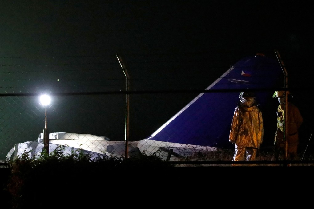 Airport officials at the scene of a medical evacuation plane crash on the runway of Manila International Airport. Photo: Reuters