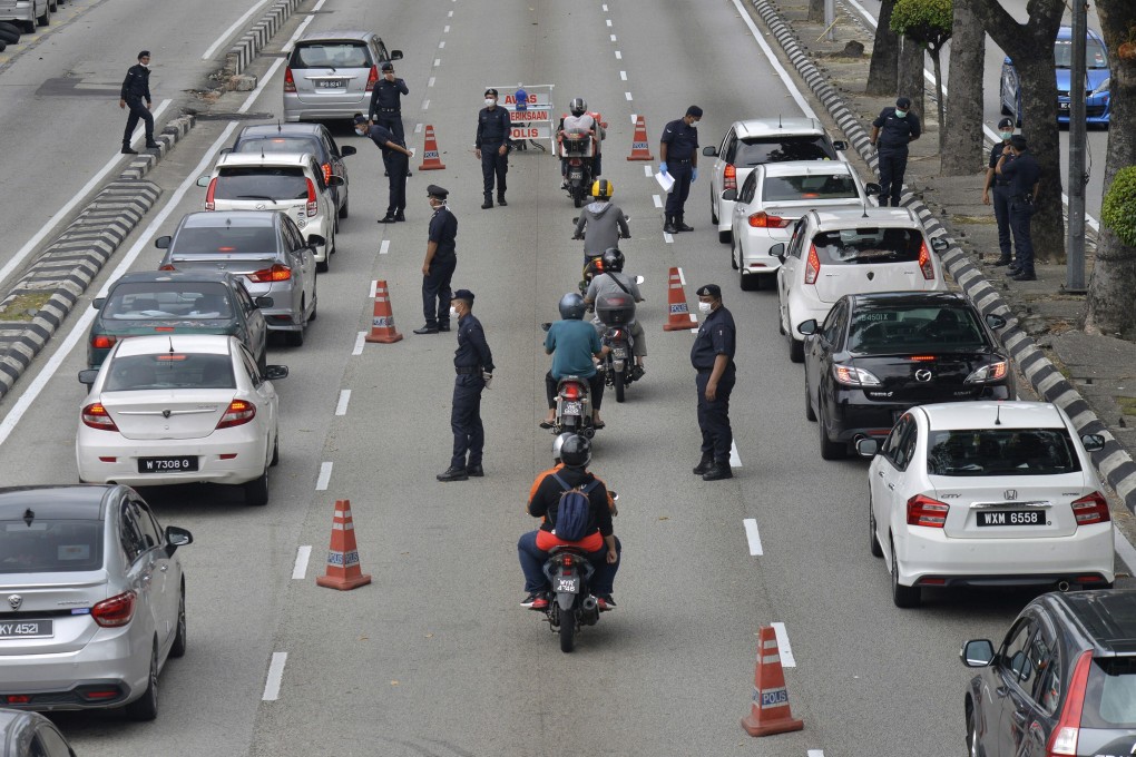 Police officers check vehicles to enforce the coronavirus lockdown in downtown Kuala Lumpur, Malaysia. Photo: AP