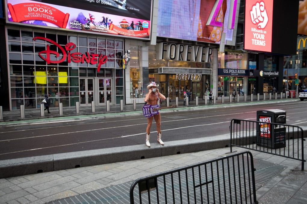 The Naked Cowboy, a regular performer at Times Square, New York, puts on a protective mask in the deserted commercial district on March 19. New York state governor Andrew Cuomo ordered businesses to keep 75 per cent of their workforce home as the number of coronavirus cases rose rapidly. Photo: Bloomberg