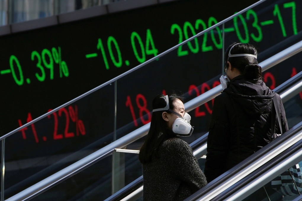 Pedestrians wearing protective masks ride an escalator near an overpass with an electronic board showing stock information at Lujiazui financial district in Shanghai. Photo: Reuters