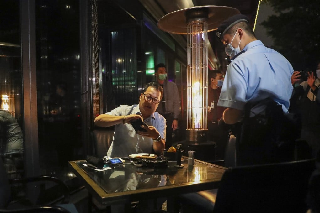 A police officer checks a pub in Tsim Sha Tsui on March 29, after the government announced a ban on gatherings of more than four people as Hong Kong recorded rising numbers of Covid-19 patients. Photo: Edmond So