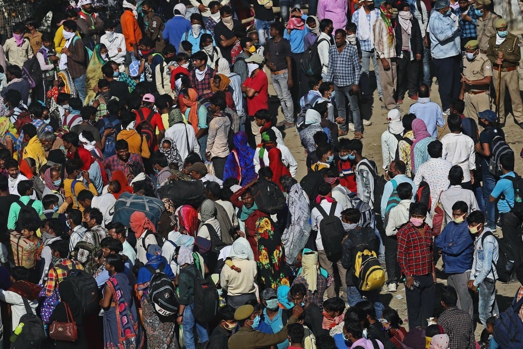Migrant workers and their families gather to try and catch buses on the outskirts of New Delhi on Sunday. Photo: Bloomberg