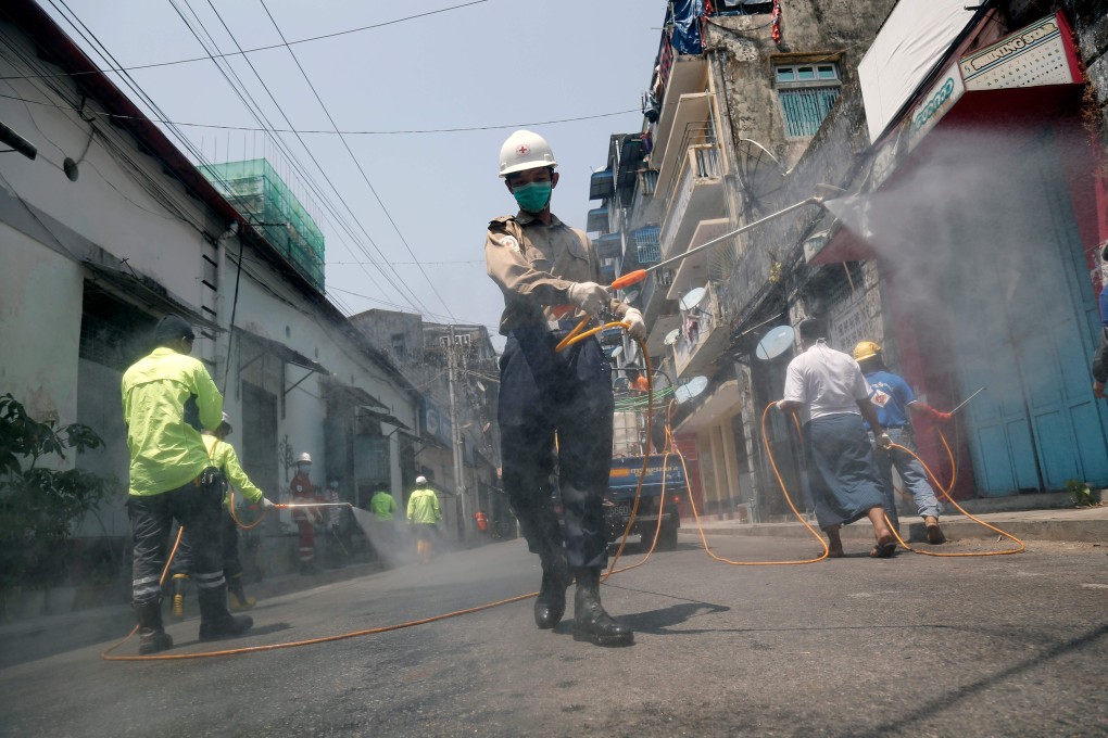 Volunteers disinfect a street as a preventive measure against the coronavirus in Yangon. Photo: AFP