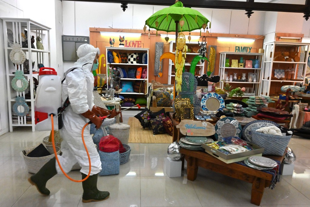 A member of the Indonesian Red Cross sprays disinfectant at a mall in Jakarta. Photo: AFP
