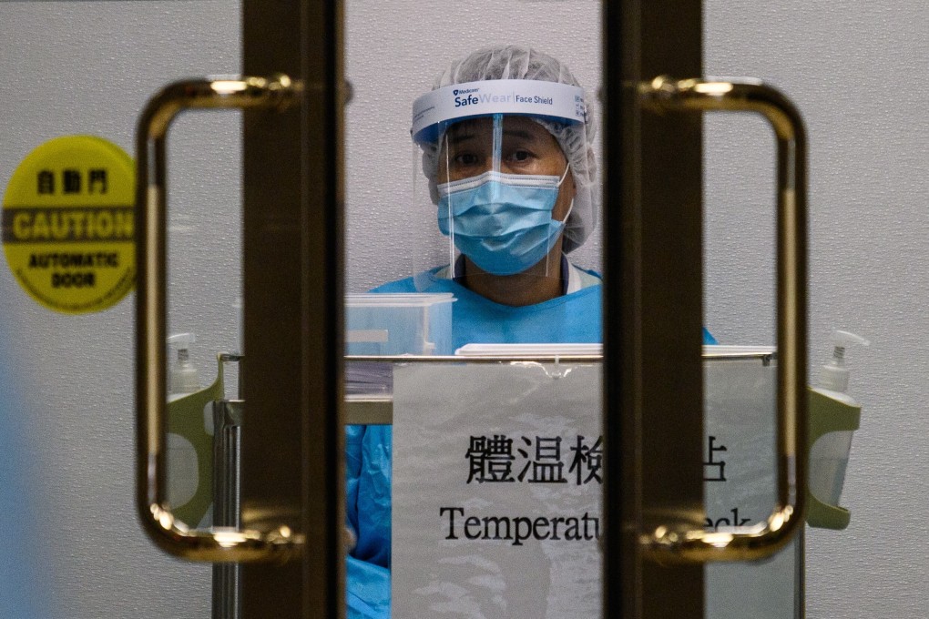 A medical worker wearing protective gear waits to take the temperature of people entering Princess Margaret Hospital in Hong Kong. Photo: AFP