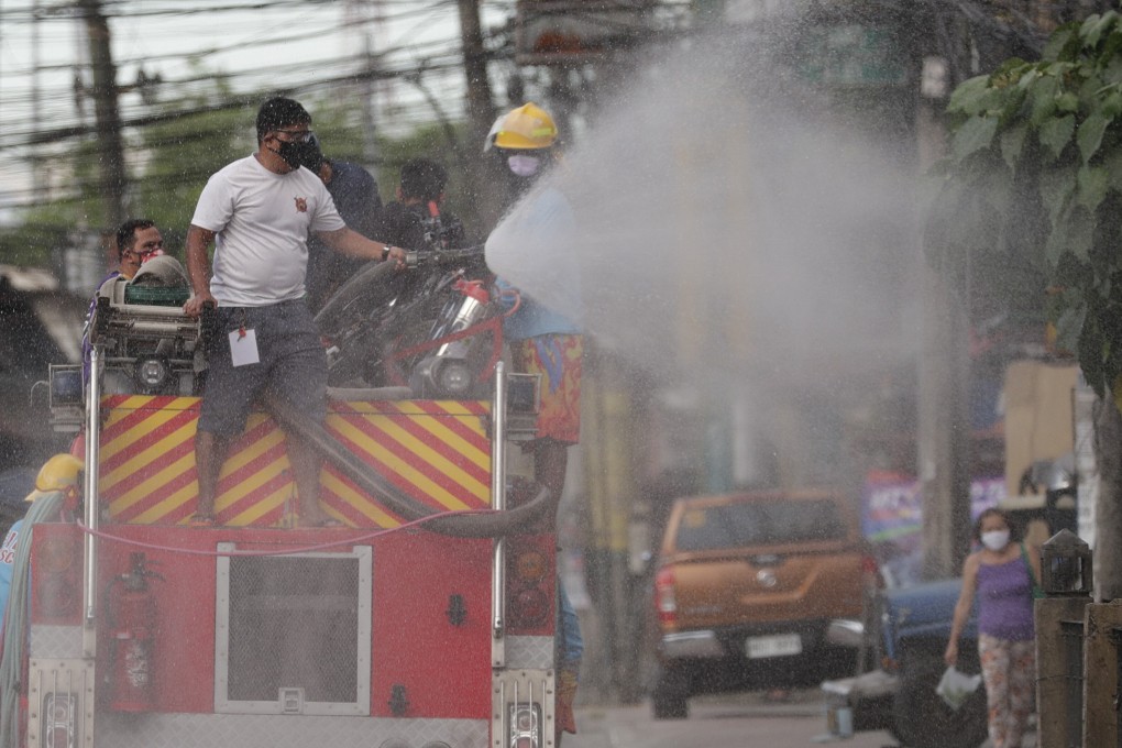 A fireman sprays disinfectant from the back of a fire truck to help curb the spread of the coronavirus during a localised quarantine in Manila. Photo: AP