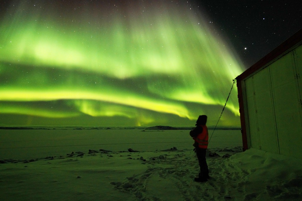 An expeditioner watches the Aurora Australis at the ADD's Davis Station in Antarctica, the only coronavirus-free continent. Photo: AFP