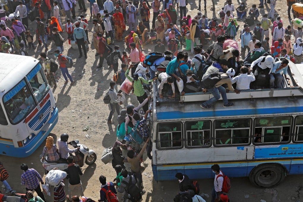 Migrant workers in Ghaziabad, on the outskirts of New Delhi, climb onto crowded buses as they try to return to their home villages during a 21-day nationwide lockdown to limit the spread of coronavirus in India. Photo: Reuters