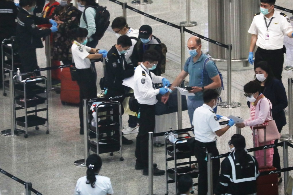 Arrivals undergo screening for the coronavirus and receive electronic wristbands to monitor their movements during the quarantine period, at Hong Kong airport on March 22. Photo: Nora Tam