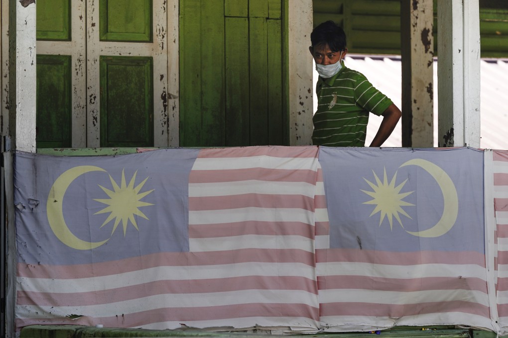 Residents wear face masks at home in Kampung Baru, a traditional Malay village in Kuala Lumpur. Photo: AP