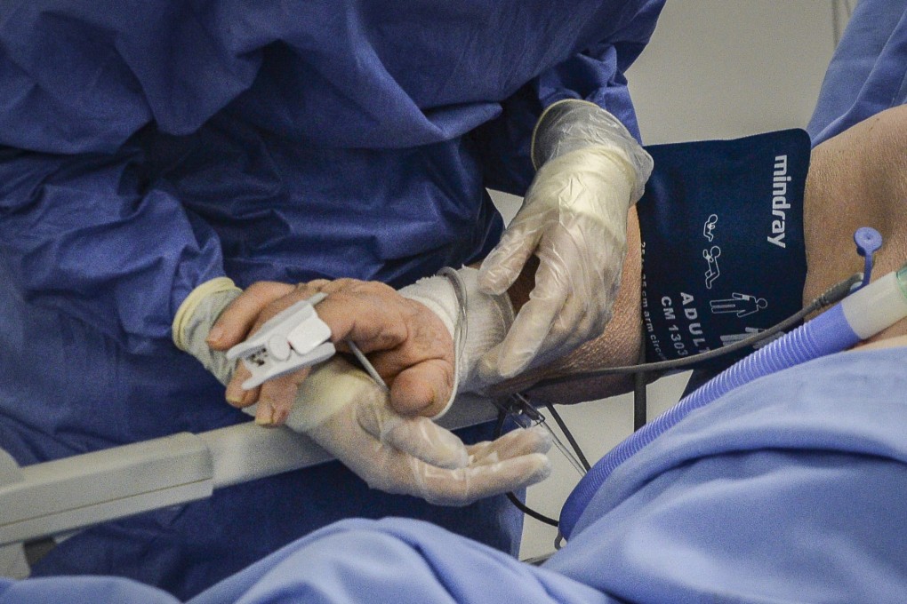 A health care worker and a patient at a newly set up intensive care unit for the treatment of Covid-19 in a hospital in Brescia, Italy, on Monday. Photo: EPA-EFE