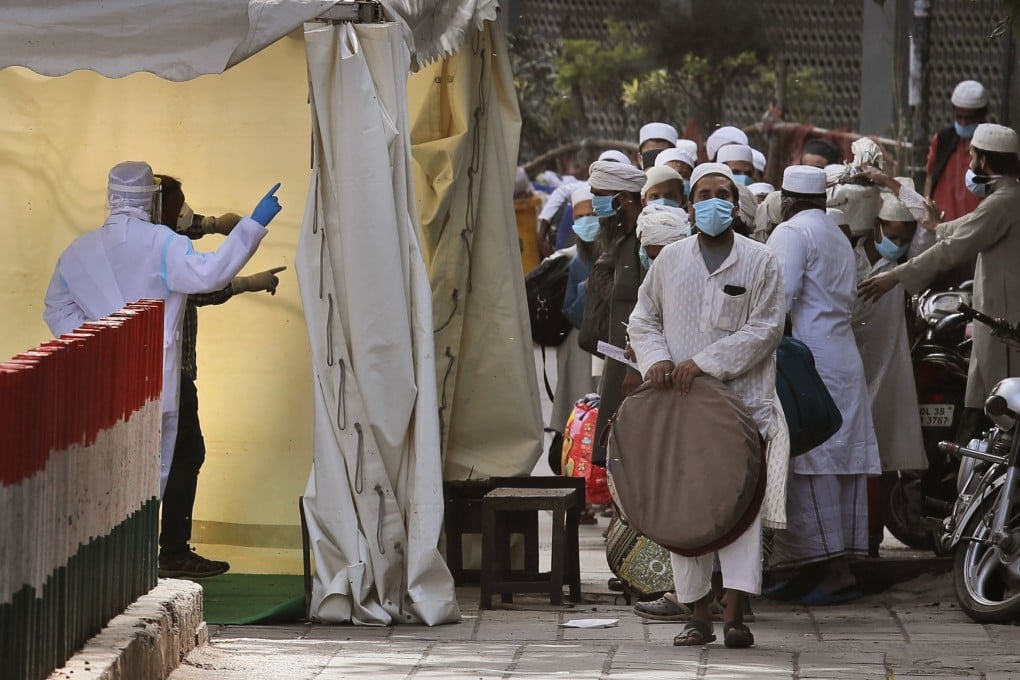 Indian paramedics facilitate the transport of Muslims to a quarantine facility, after several people who attended an Islamic congregation earlier this month in the Nizamuddin area of New Delhi tested positive for Covid-19. Photo: AP