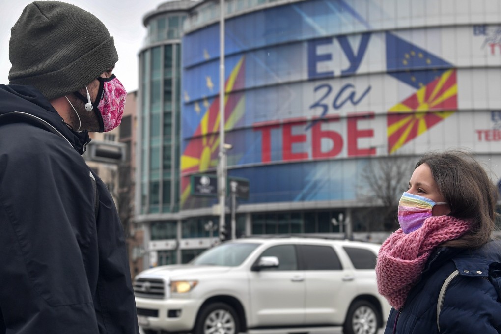 People wearing face masks talk in front of the EU office in Skopje, North Macedonia. Photo: EPA-EFE