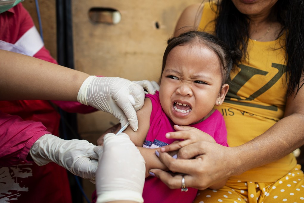 A child receives a vaccination from a health worker in the Philippines last year. Photo: AFP