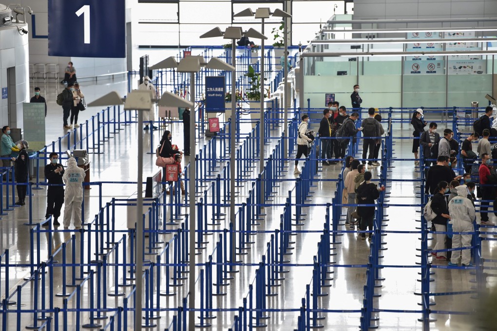 Passengers wearing face masks, amid concerns of the Covid-19 coronavirus, queue at check-in counters at Shanghai Pudong International Airport in Shanghai on March 18. Photo: AFP