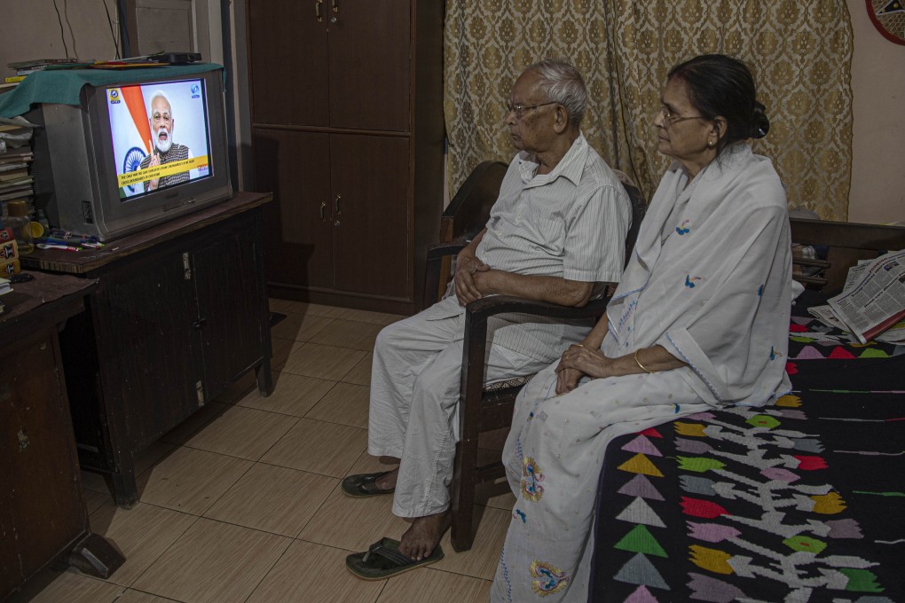 An elderly Indian couple in Gauhati watch Prime Minister Narendra Modi address the nation in a televised speech about the Covid-19 pandemic. The lockdown has negatively impacted many of India’s elderly. Photo: AP