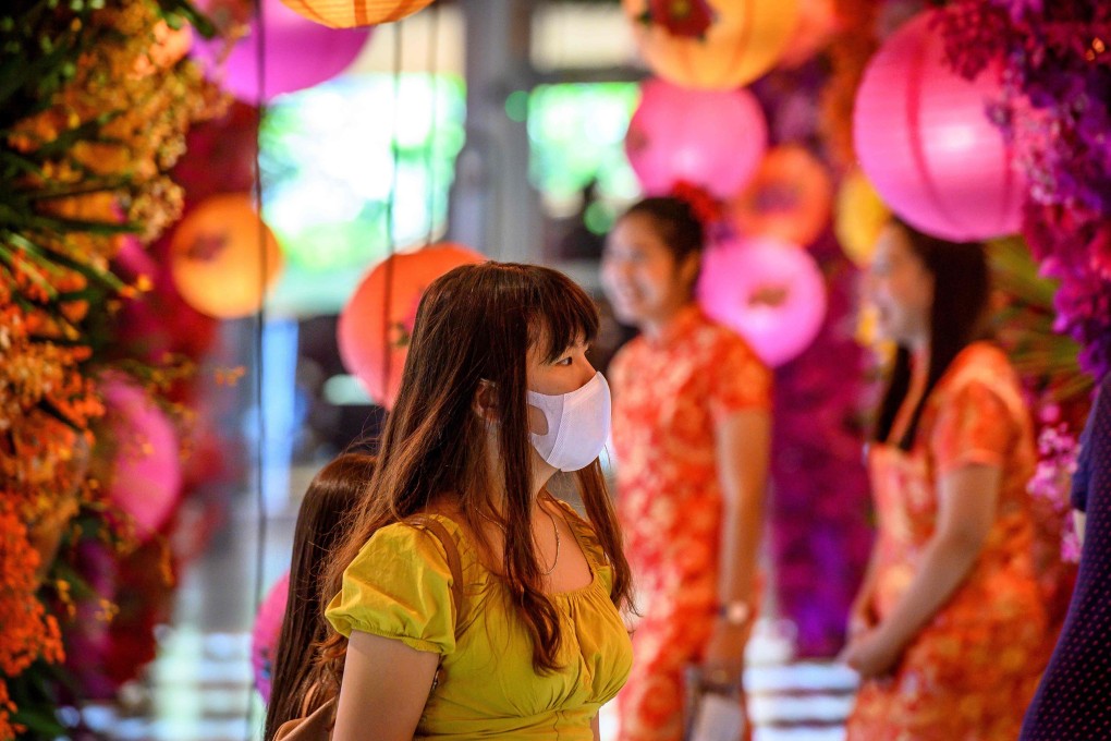 A woman in a face mask walks through a shop decorated for the Lunar New Year in Bangkok on January 24. Photo: AFP