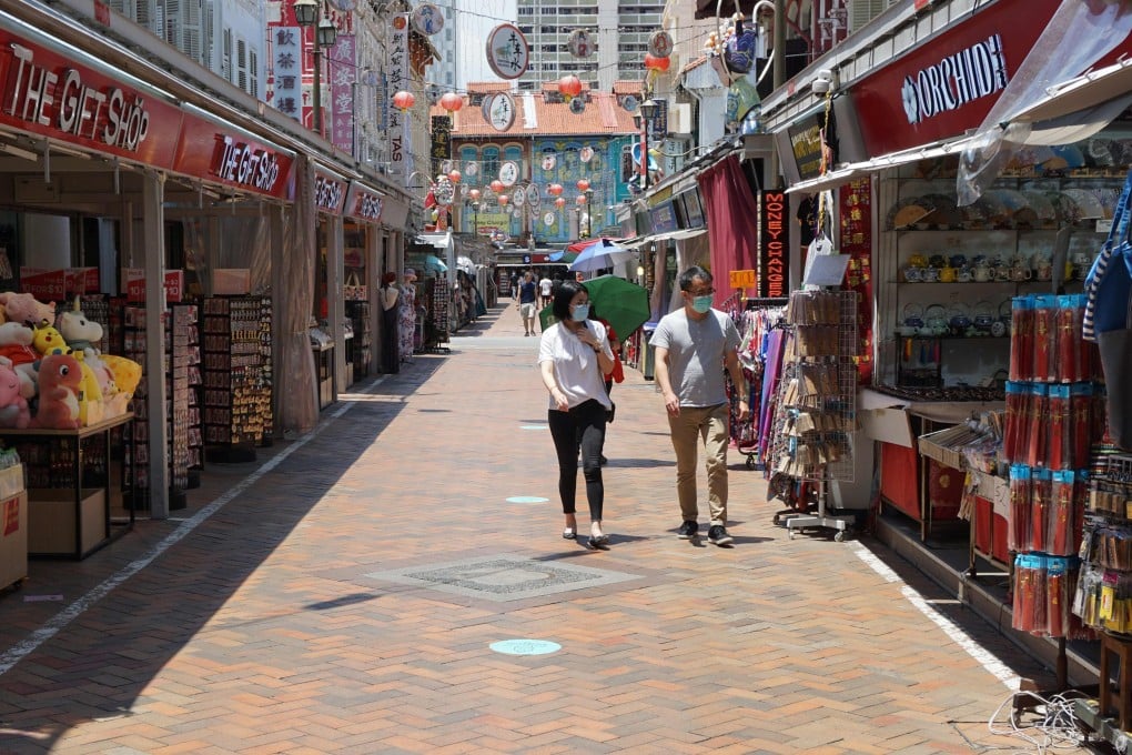 People wearing face masks walk past shops in Chinatown in Singapore. Photo: AFP