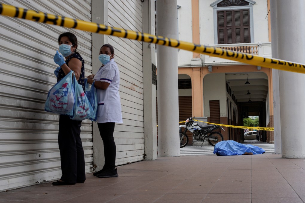Women stand near a dead body on the pavement in Guayaquil, Ecuador. Photo: Reuters
