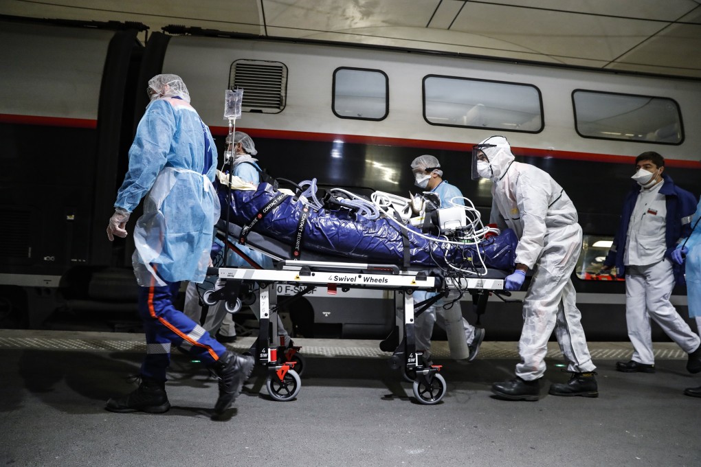 Medical staff transfer a patient infected with the coronavirus to a train at the Gare d'Austerlitz station in Paris. Photo: AP