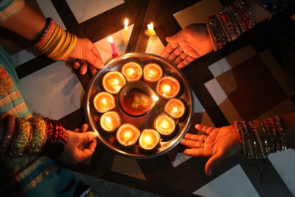 Indian women light earthen lamps and candles at Jalot village, some 50km from Dharamsala, on Sunday. Photo: EPA-EFE