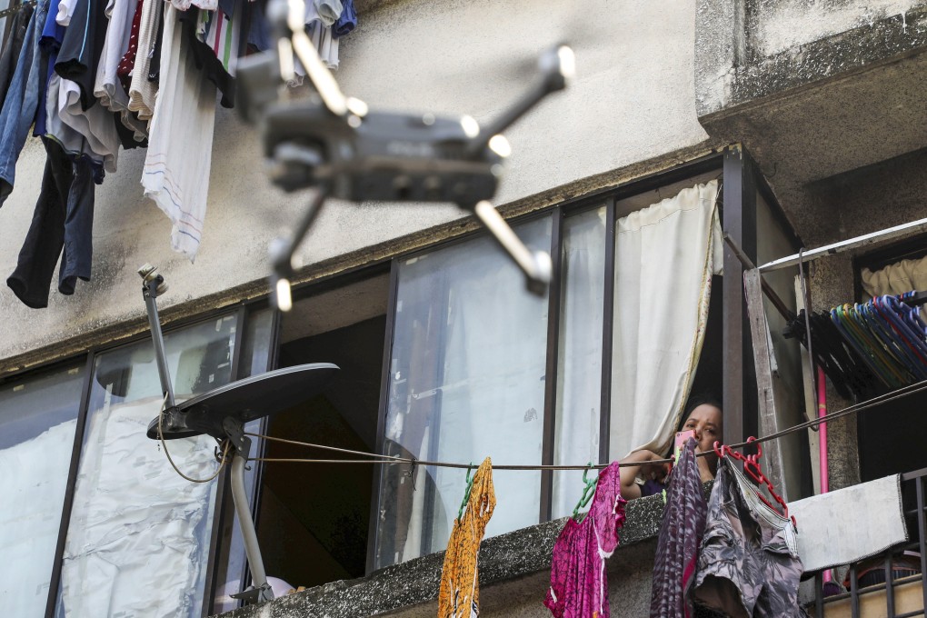 A woman watches a drone, used by the Malaysian police to remind people to stay at home during a lockdown imposed to contain the spread of Covid-19, in Kuala Lumpur on March 24. Photo: Reuters