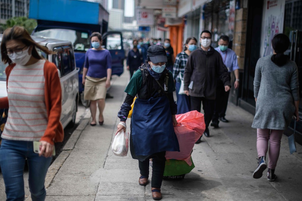 May May, a McRefugee, walks towards her rented storage space after receiving a free meal box from a social enterprise on March 27. Photo: AFP
