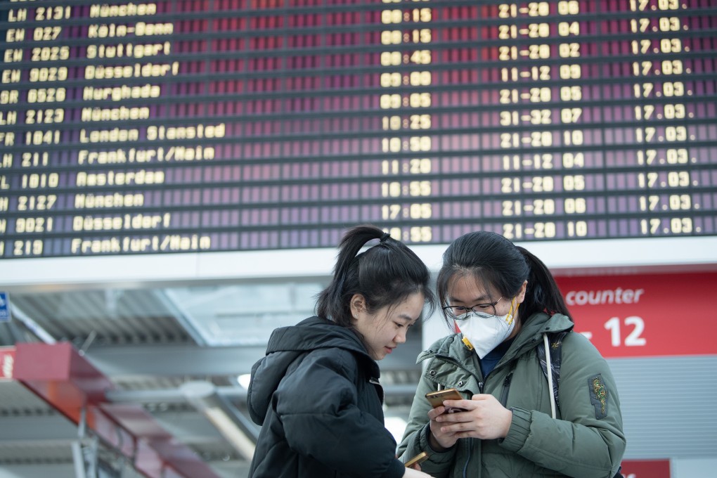 Chinese students stand in front of a departure board at Dresden Airport in Germany in March, as numerous flights are cancelled due to the coronavirus outbreak. Photo: dpa