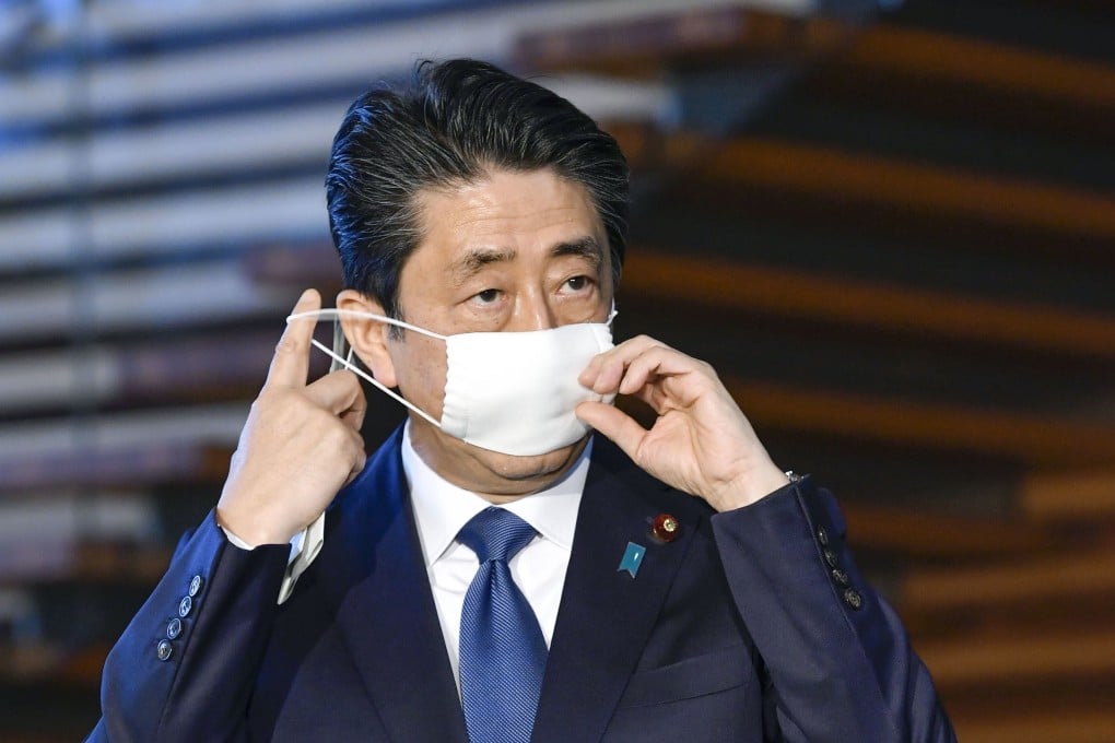 Japanese Prime Minister Shinzo Abe takes his mask off before announcing plans to declare a state of emergency over the spread of the new coronavirus. Photo: Kyodo