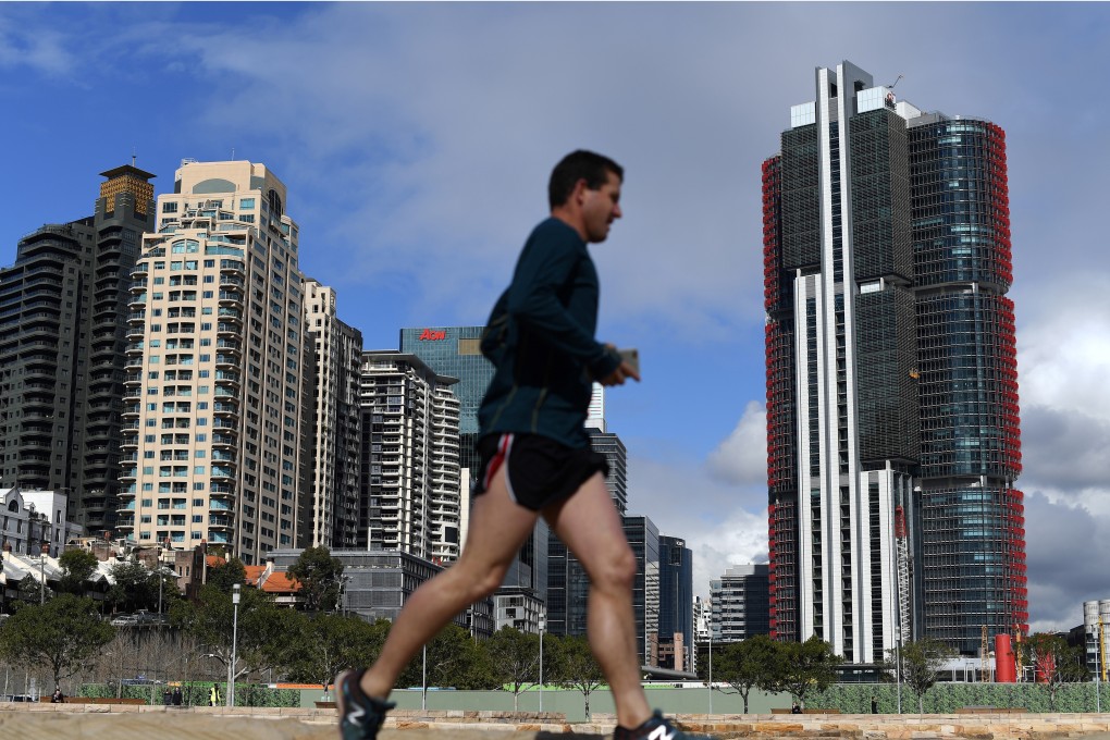 A man jogs in front of newly constructed residential and commercial projects in Sydney. Overseas properties have become cheaper as regional currencies weakened against Hong Kong’s pegged dollar. Photo: AFP