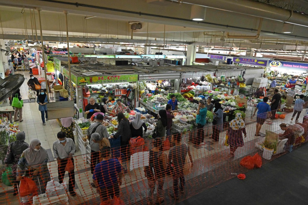 People shop for food items inside a barricade at the Geylang Serai market in Singapore. Photo: AFP