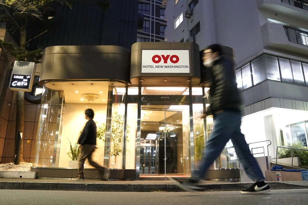 Pedestrians walk past an Oyo hotel in Tokyo. The start-up is placing thousands of employees on indefinite leave in a bid to survive the coronavirus pandemic. Photo: Bloomberg