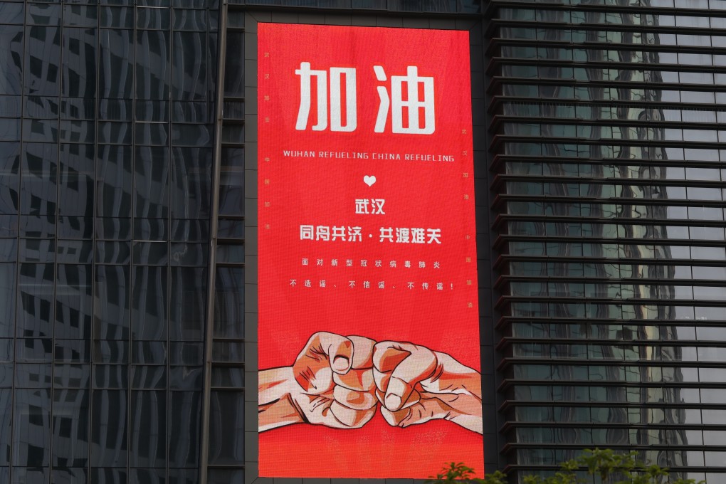 A big screen on a building says: Fight On Wuhan, a day before the city reopened on April 8. China is emerging from lockdown ahead of other countries. Photo: Simon Song