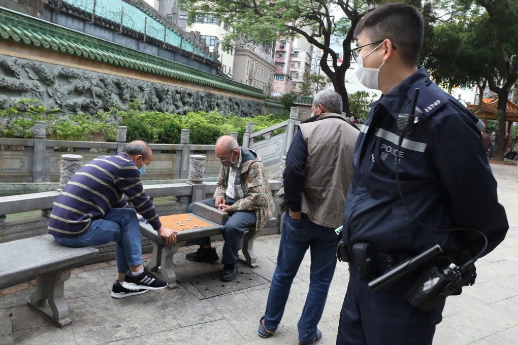 A police officer patrols a park in Yau Ma Tei where elderly men have gathered to play chess amid the coronavirus outbreak. Photo: Dickson Lee