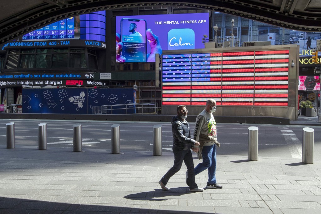 People wear masks to fend off the coronavirus as they walk in Times Square in New York on Tuesday. Photo: AP