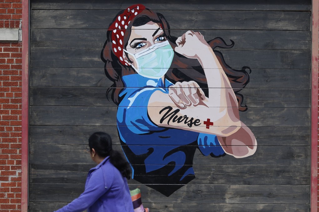 A woman walks past a mural paying tribute to nurses near a hospital in Dallas on Tuesday. Photo: AP