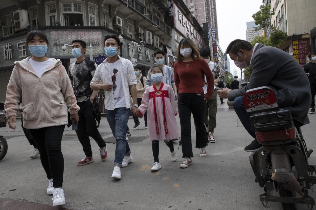 People walk along a retail street in Wuhan on Wednesday as lockdown measures were eased. Photo: AP