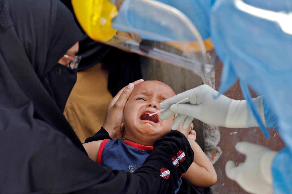 A child cries as a doctor wearing protective gear takes a swab to test for coronavirus in the northern Indian city of Ahmedabad on Wednesday. Photo: Reuters
