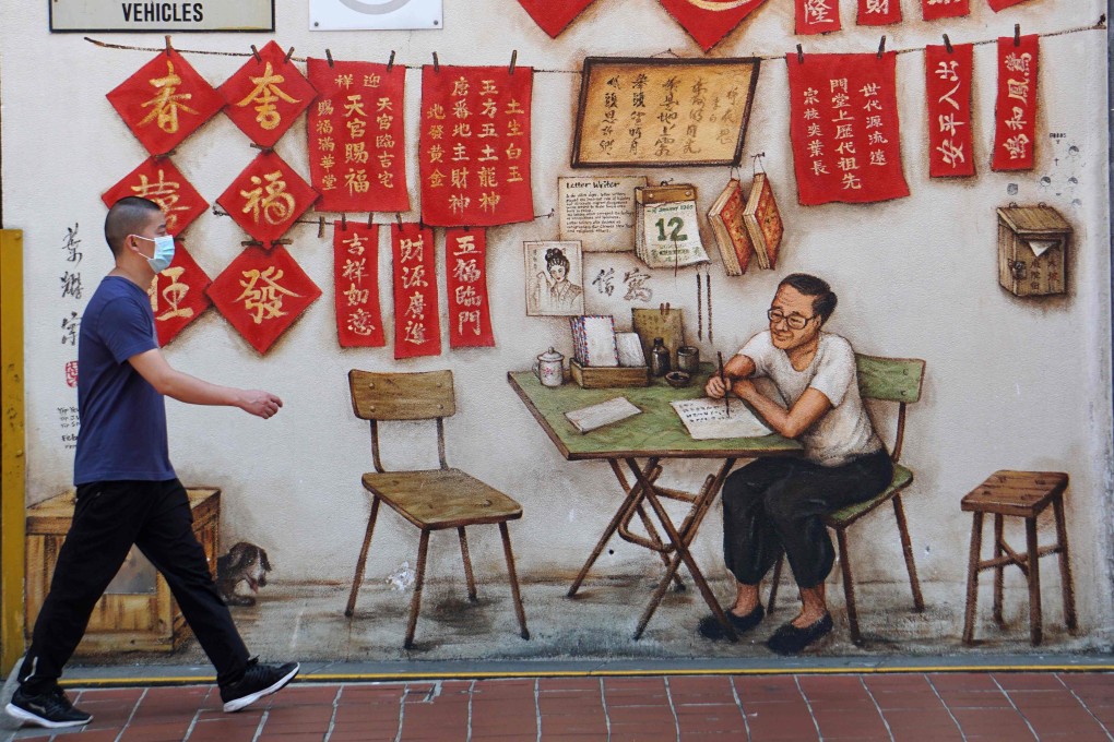 A man wearing a face mask walks past a mural in Chinatown in Singapore. The Chinese embassy has intensified its outreach campaign to citizens currently in the city state. Photo: AFP