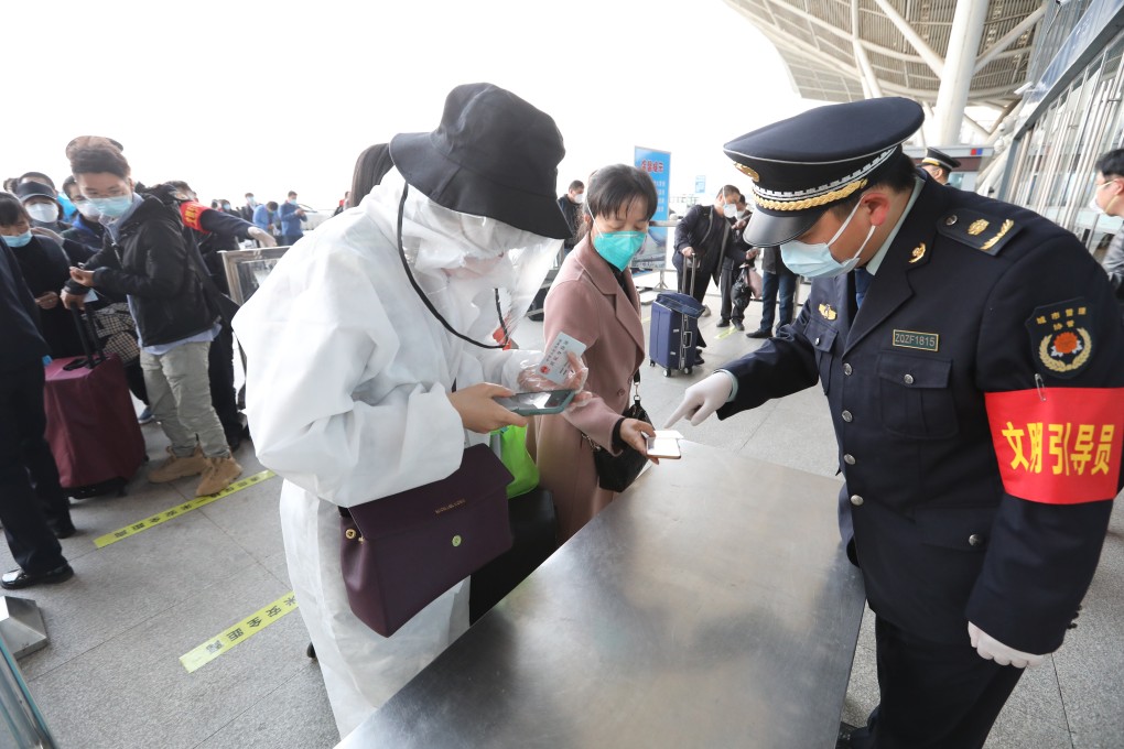 Officials at Wuhan Railway Station check passenger codes as the city’s travel lockdown lifts. Photo: Simon Song