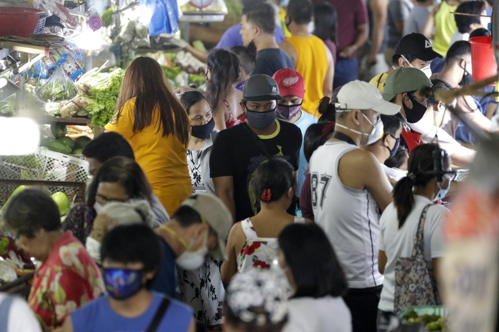 People wearing masks buy food at a market in Metro Manila, Philippines. Photo: AP