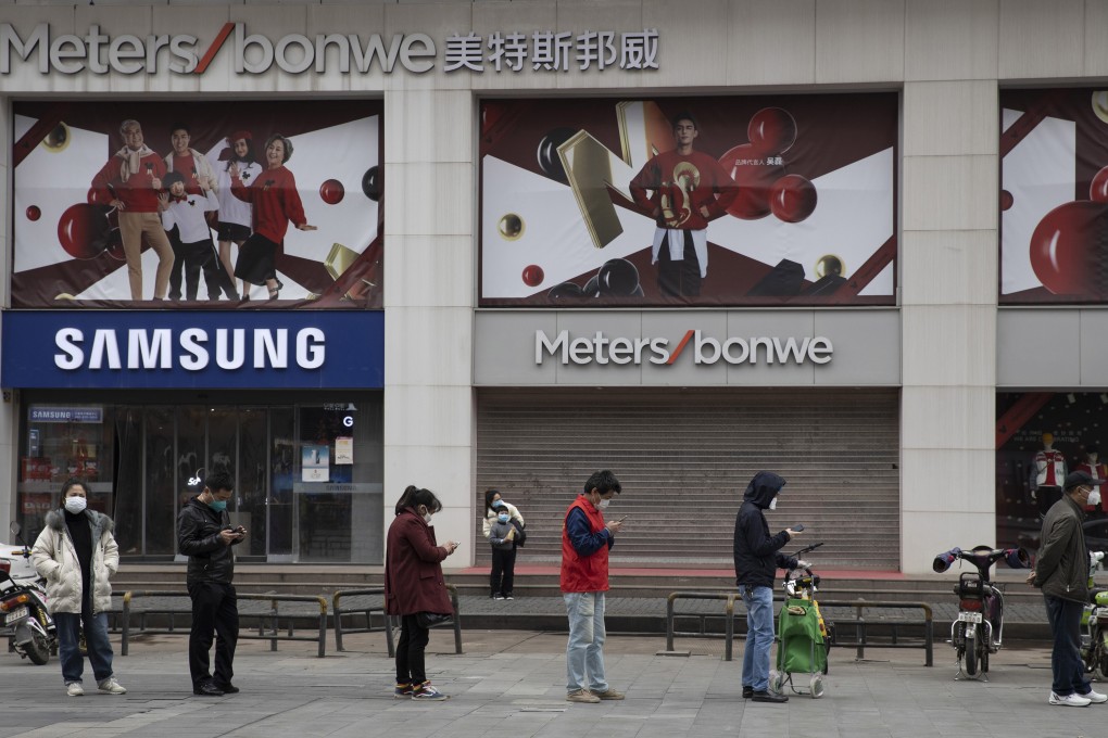 Residents line up to enter a supermarket in Wuhan on Friday. Photo: AP