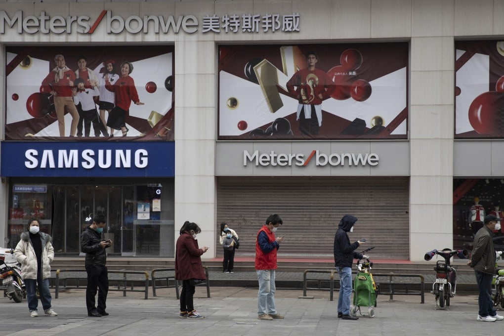 Residents line up to enter a supermarket in Wuhan on Friday. Photo: AP