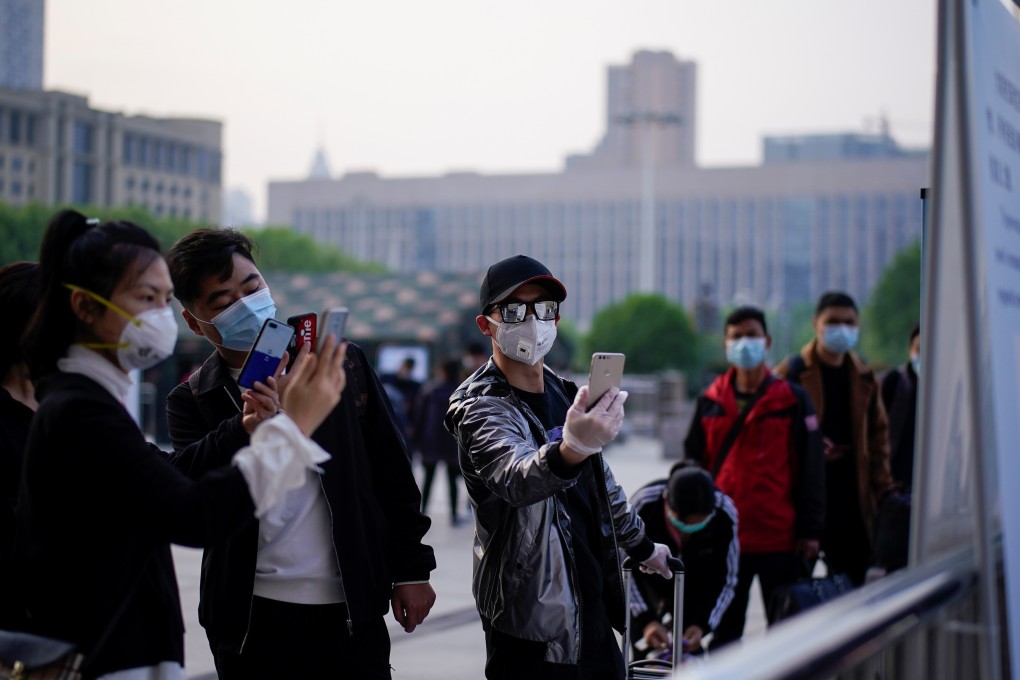 People scan a health QR code at Wuhan’s Hankou Railway Station on Wednesday, the day travel restrictions on leaving the city were lifted. Photo: Reuters