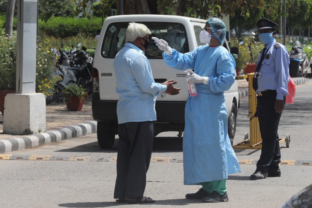 A health worker checks the body temperature of a man entering a hospital in New Delhi, India, as the country extends its nationwide lockdown to contain the spread of Covid-19. Photo: EPA-EFE