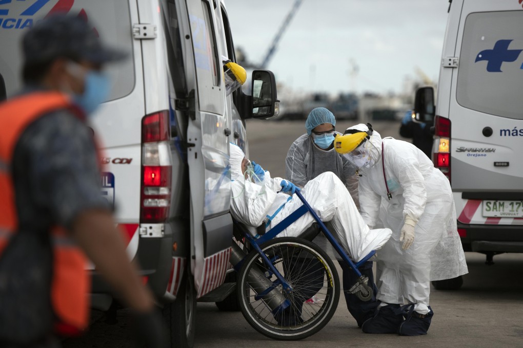 A suspected coronavirus patient from the Australian cruise ship Greg Mortimer is taken by military personnel to a local hospital in Uruguay earlier this week. Photo: AP