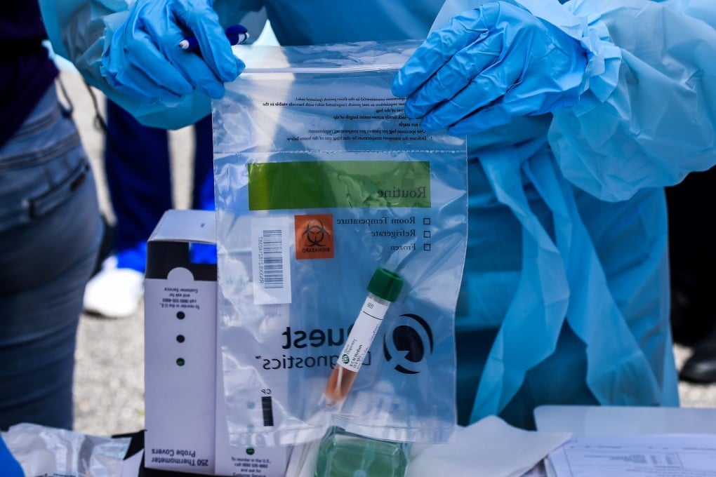 A medical worker handles patients’ samples at a coronavirus testing lab set up by the local community centre in West Palm Beach, north of Miami, in the US, on March 30. The Covid-19 pandemic has trounced existing international coordination mechanisms on disease control and prevention, exposing the fragile security system in which we live. Photo: AFP